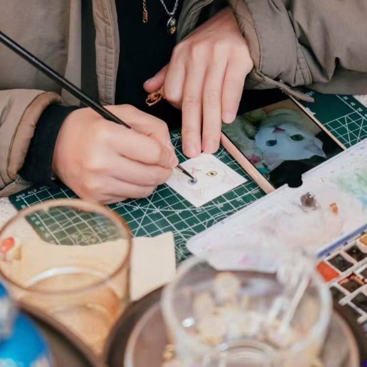 Artist hand-painting a custom white cat portrait in watercolor